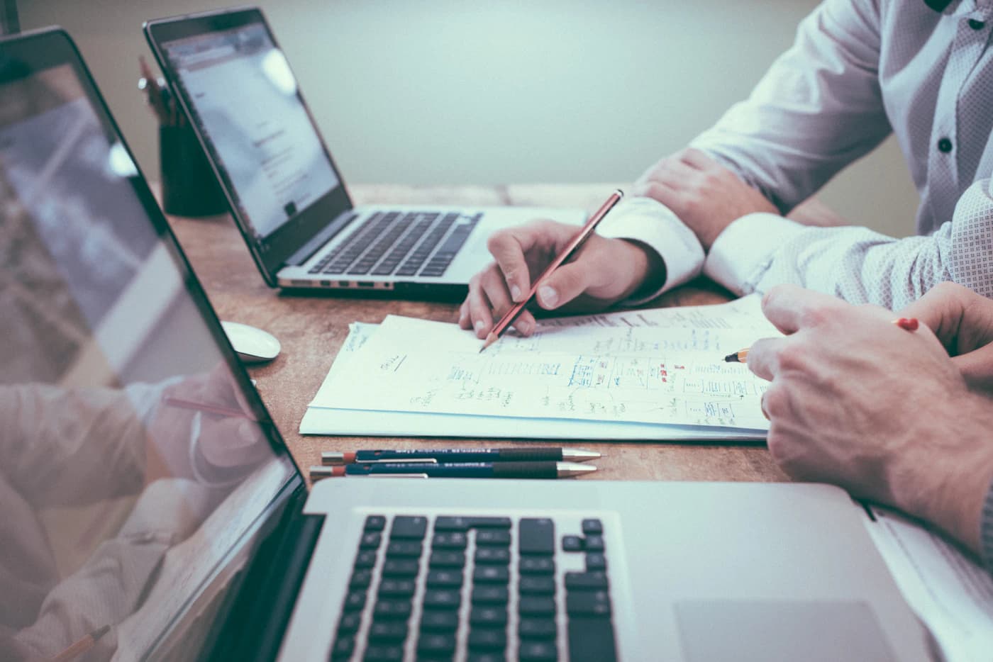 Two people reviewing a website plan together beside open laptops